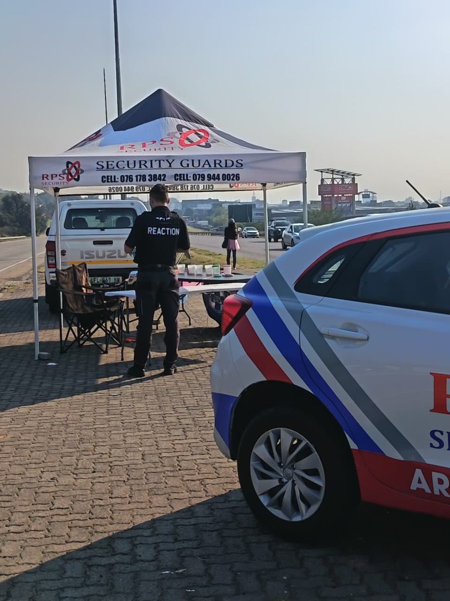 An RPS Security reaction officer beside a marked vehicle at a roadside deployment in Rustenburg